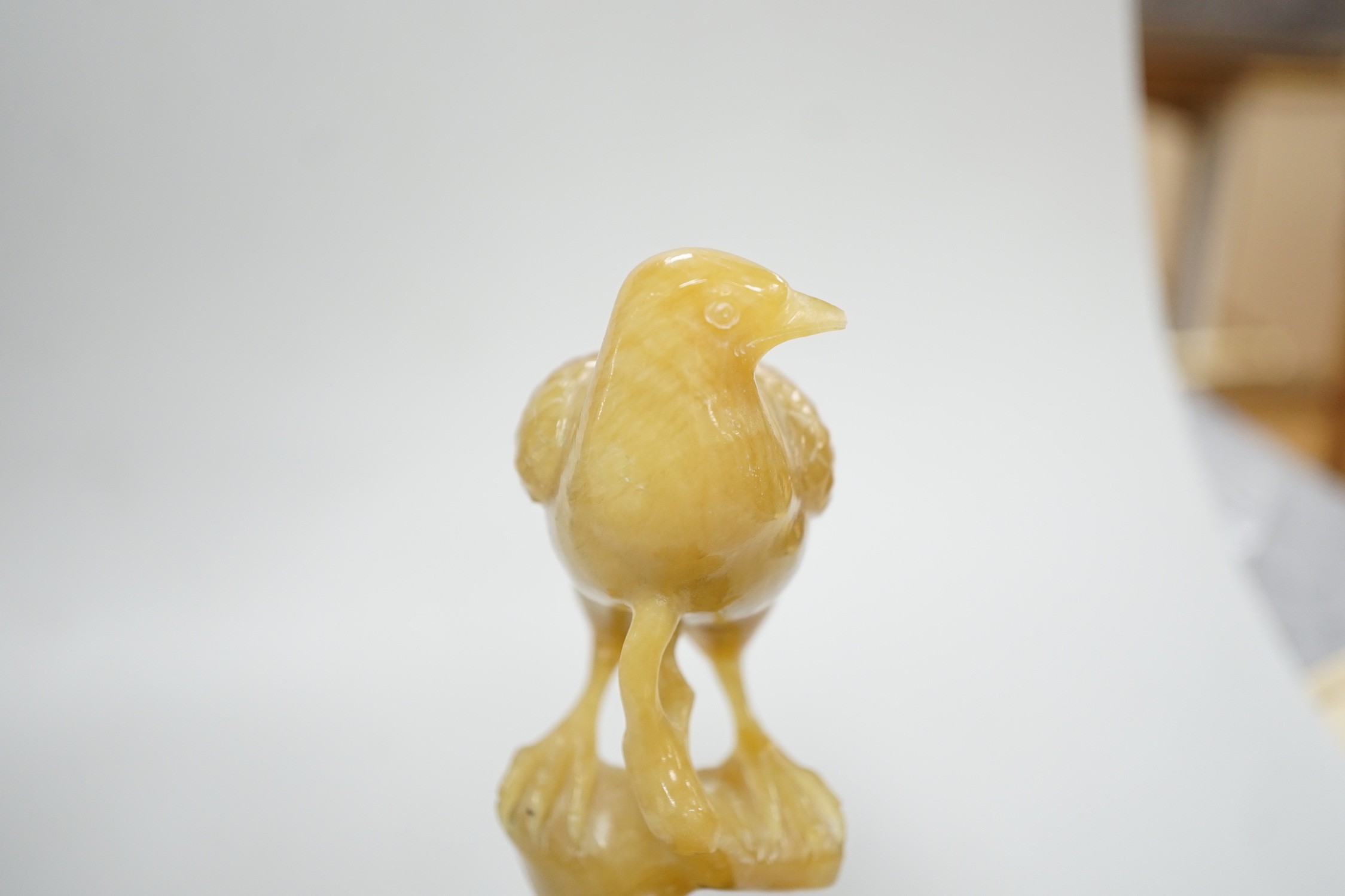 A Chinese chalcedony carving of a bird, wood stand, total height 15.5 cm
